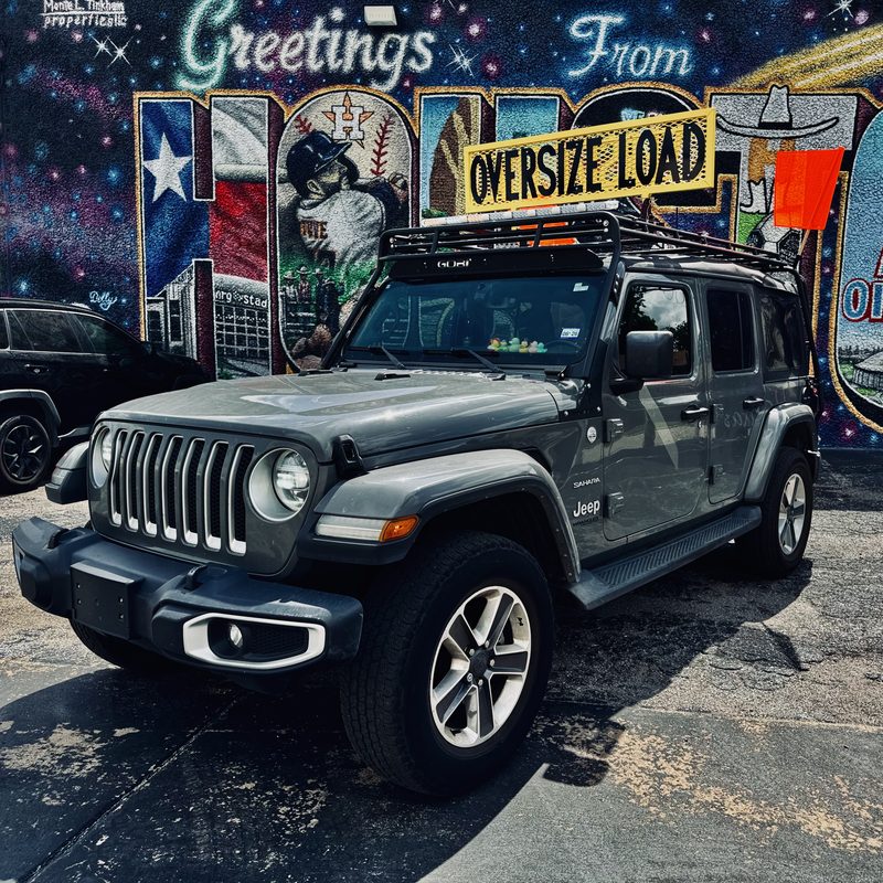 Space City Cruise Collective pilot car — Jeep Wrangler with OVERSIZE LOAD sign in front of Houston mural